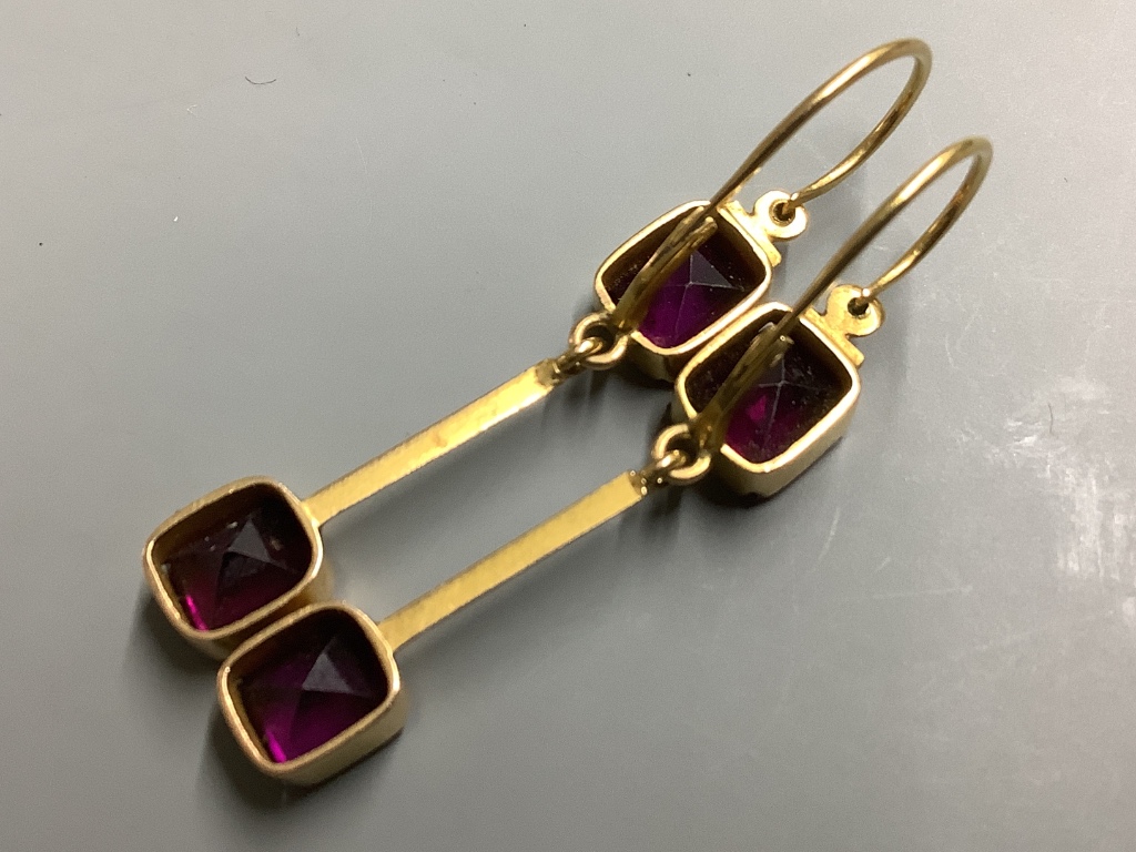 A pair of yellow metal and garnet set drop earrings